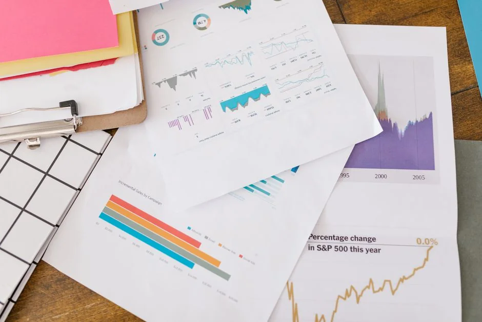 Business analysis centered on charts and graphs displayed on a laptop in a contemporary office environment.